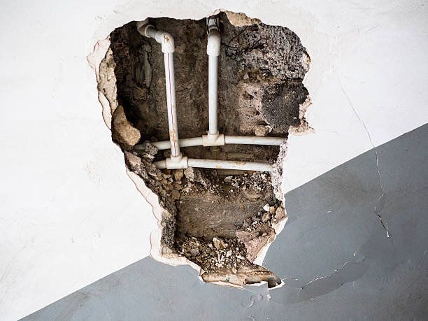 view of new plastic water pipes in broken wall of old apartment building Water Leak Detection